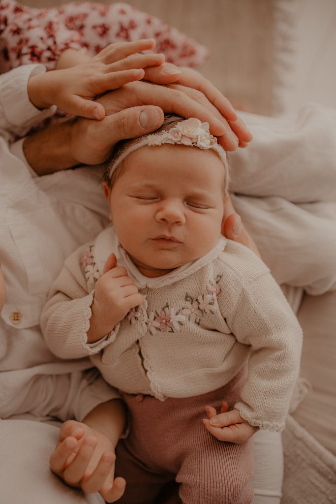 bébé enveloppé des mains de toute sa famille
