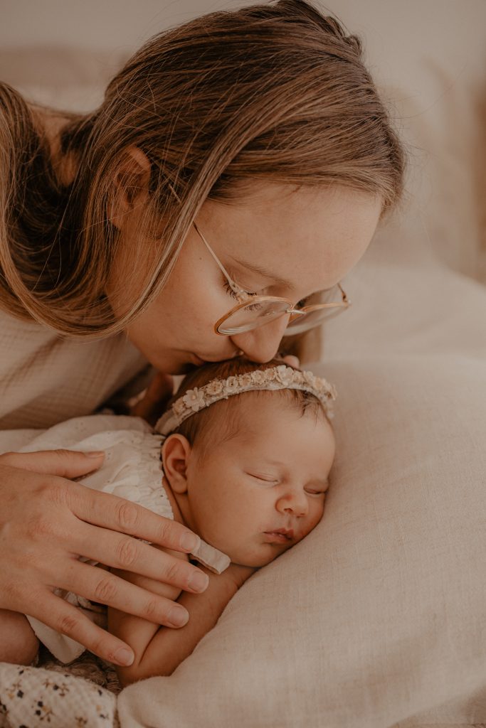 Tendre bisou de maman sur la tête de son bébé