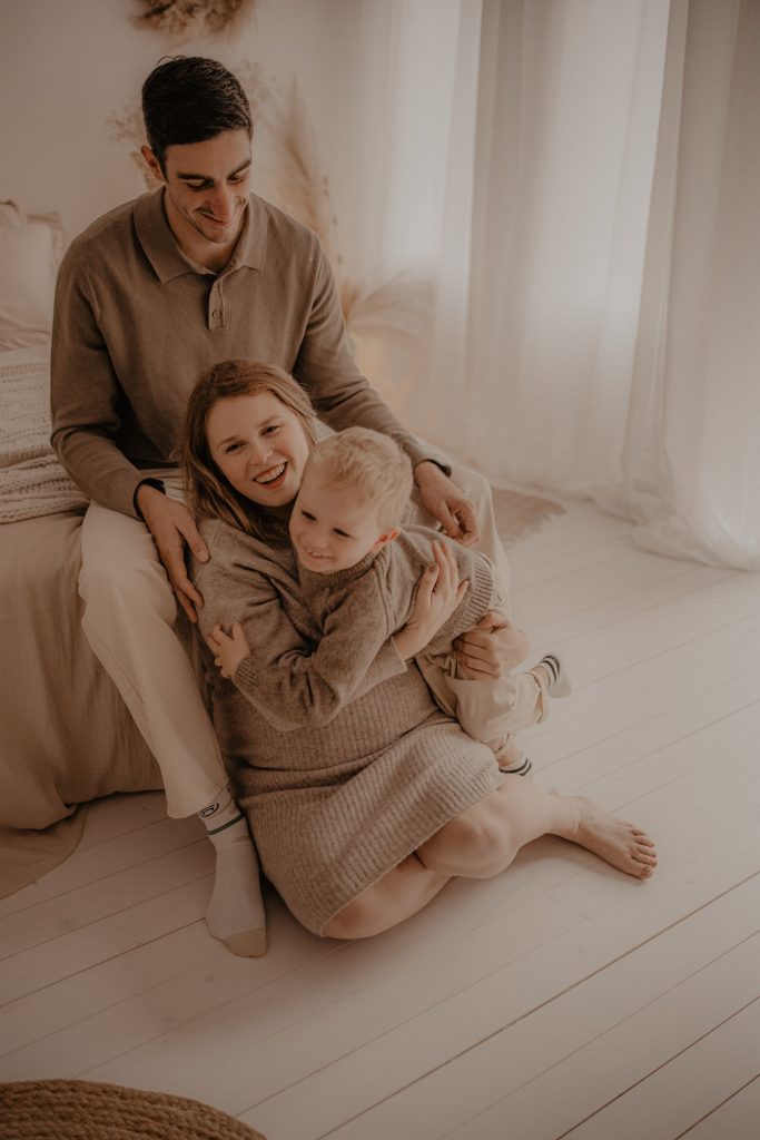 Câlin du grand frère sur le ventre de maman
