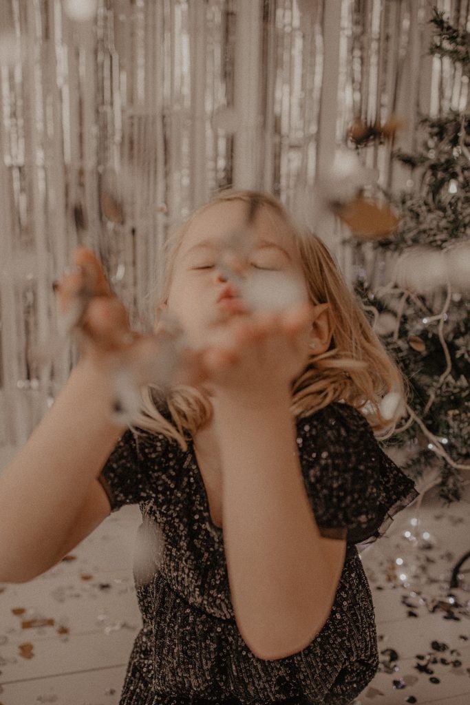 Petite fille qui souffle sur les confettis