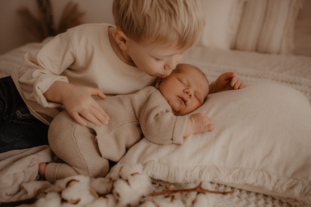 Grand frère fait un bisou à bébé