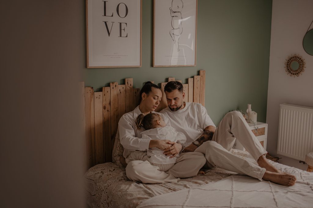 Enfant blotti dans les bras de ses parents