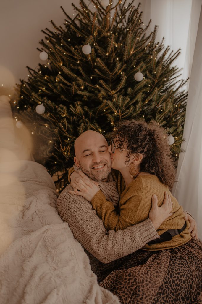 Couple amoureux devant le sapin de Noël