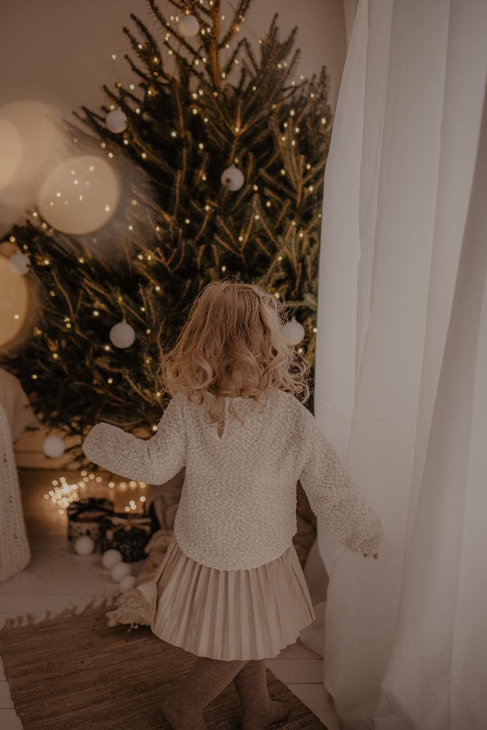 Enfant qui joue devant le sapin de Noël à Douai