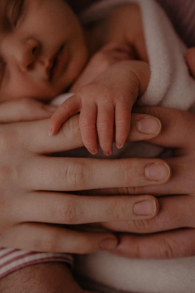 Main de bébé sur les mains de papa et maman