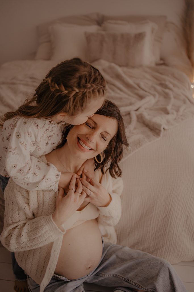 Future maman et sa fille pour un moment calin en photo