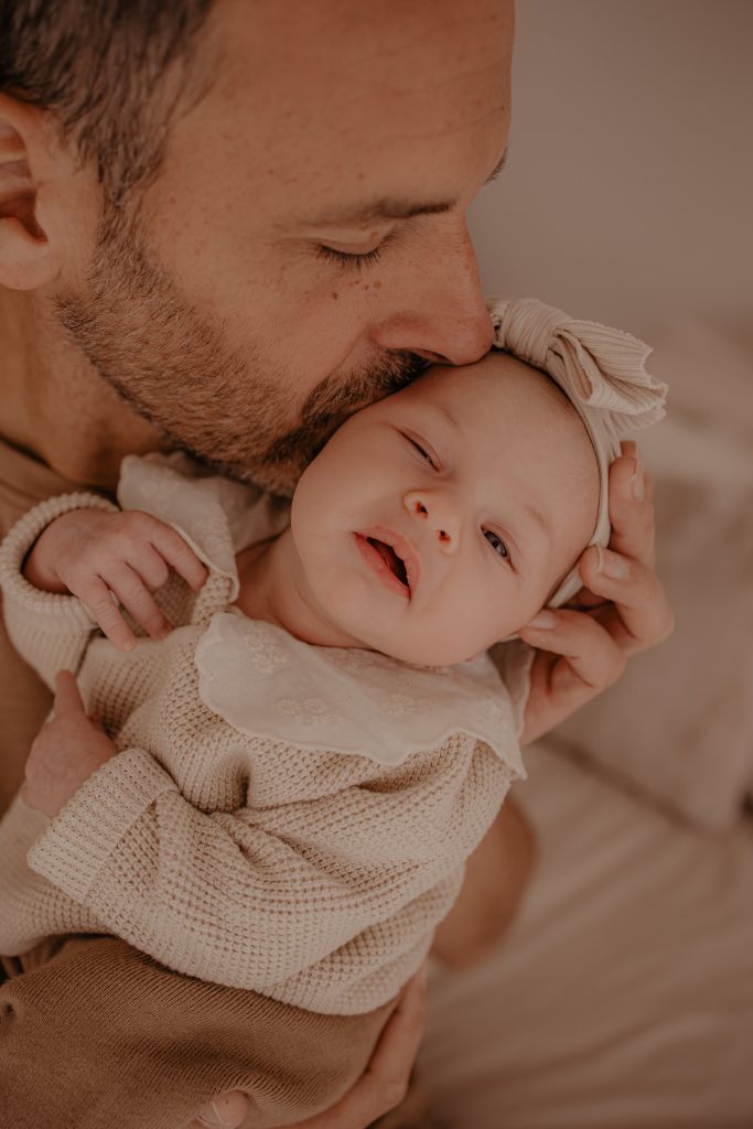 Photo papa qui fait un bisou à bébé